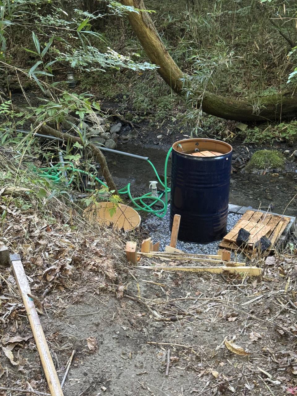 沢のかたわらに据えたドラム缶の水風呂と導水ホース